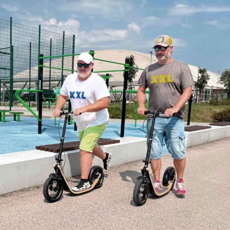 two men riding boardies on a sidewalk