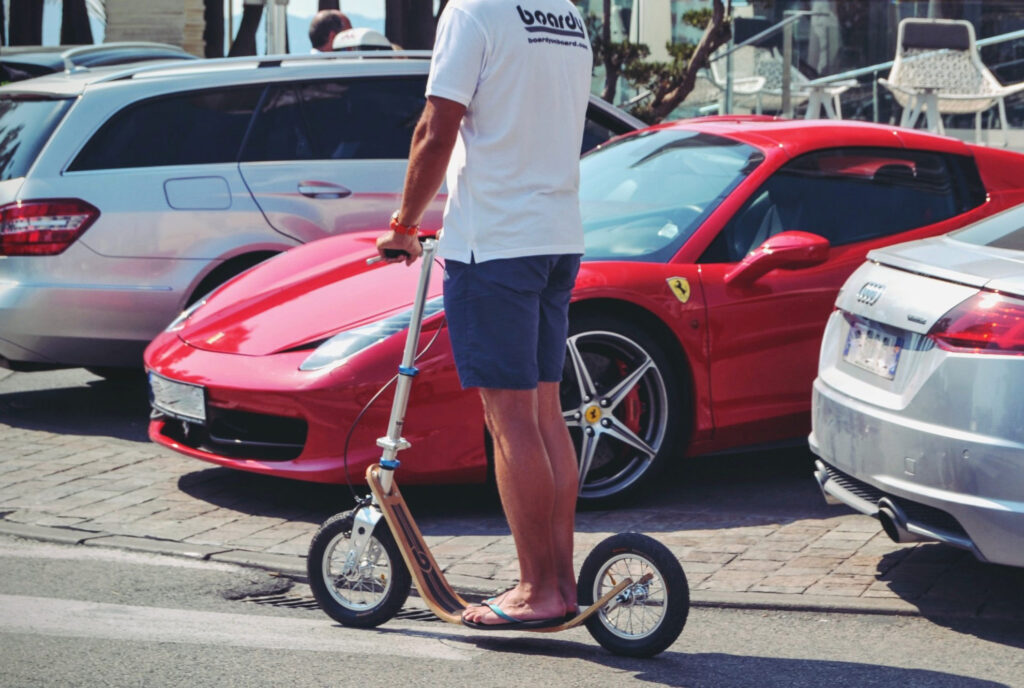 Wide deck boardscooter allowing feet side by side stance for stable riding position.