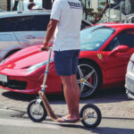 Wide deck boardscooter allowing feet side by side stance for stable riding position.