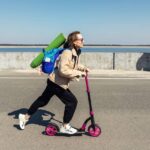 Kick Scooter - A woman using a push scooter on the road