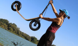 woman lifting scooter overhead