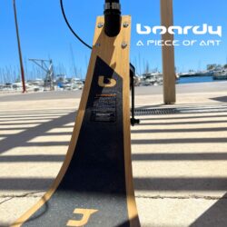 Design That Speaks For Itself close-up of the front panel of a boardy scooter with sunlit shadows and branding visible.