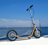 Nautical Style Meets Portability boardy scooter parked on a boat deck with open sea in the background.