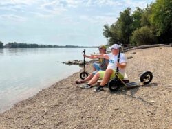 Scooter. Chill. Repeat. relaxing by the riverside with their boardy scooters beside them.