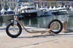 Stillness And Style boardy scooter parked at a dockside with reflections on the water.