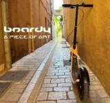 A Piece Of Art boardy scooter in a narrow cobblestone alley. a piece of art.