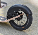 Fender Focus close-up of the rear wheel and fender of a boardy scooter.