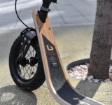 Curbside Rest close-up of the front wheel and wooden deck with a handbrake assembly.