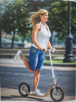 City Stroll alexandra beres riding a boardy scooter down a city street.